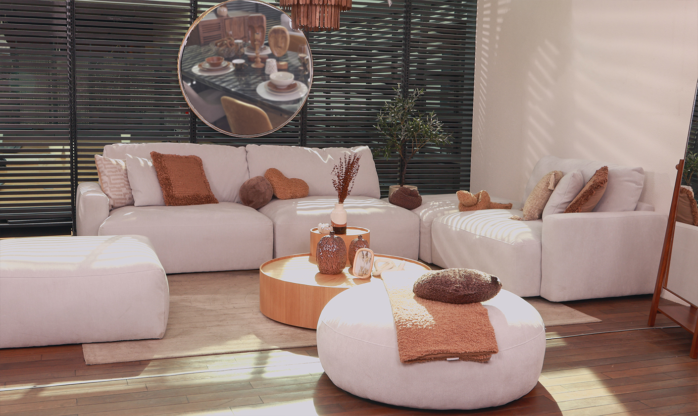 Modern neutral living room with upholstered sofas, wooden furniture, and warm decorative accents.