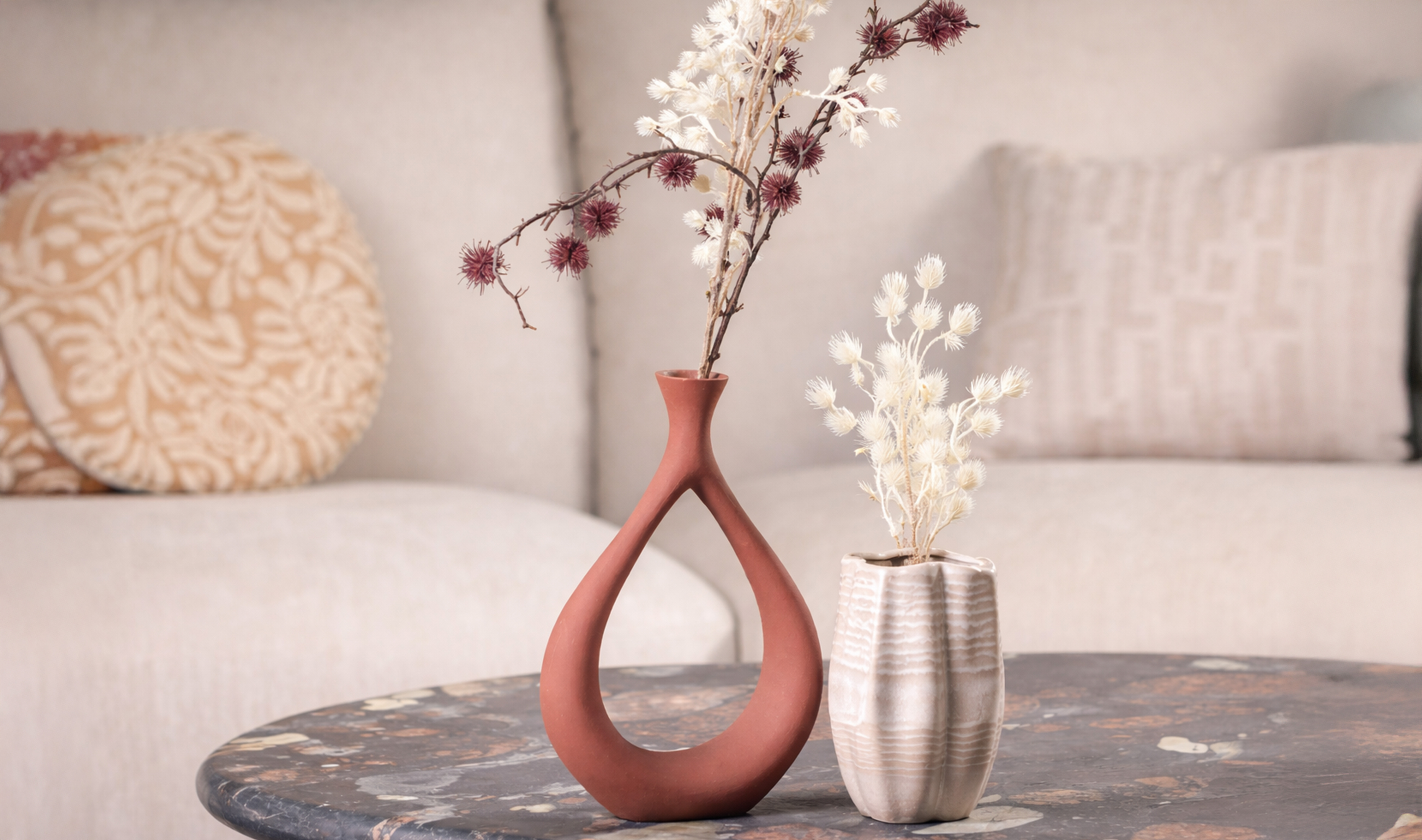 Modern decorative vase with dried florals on a marble table.
