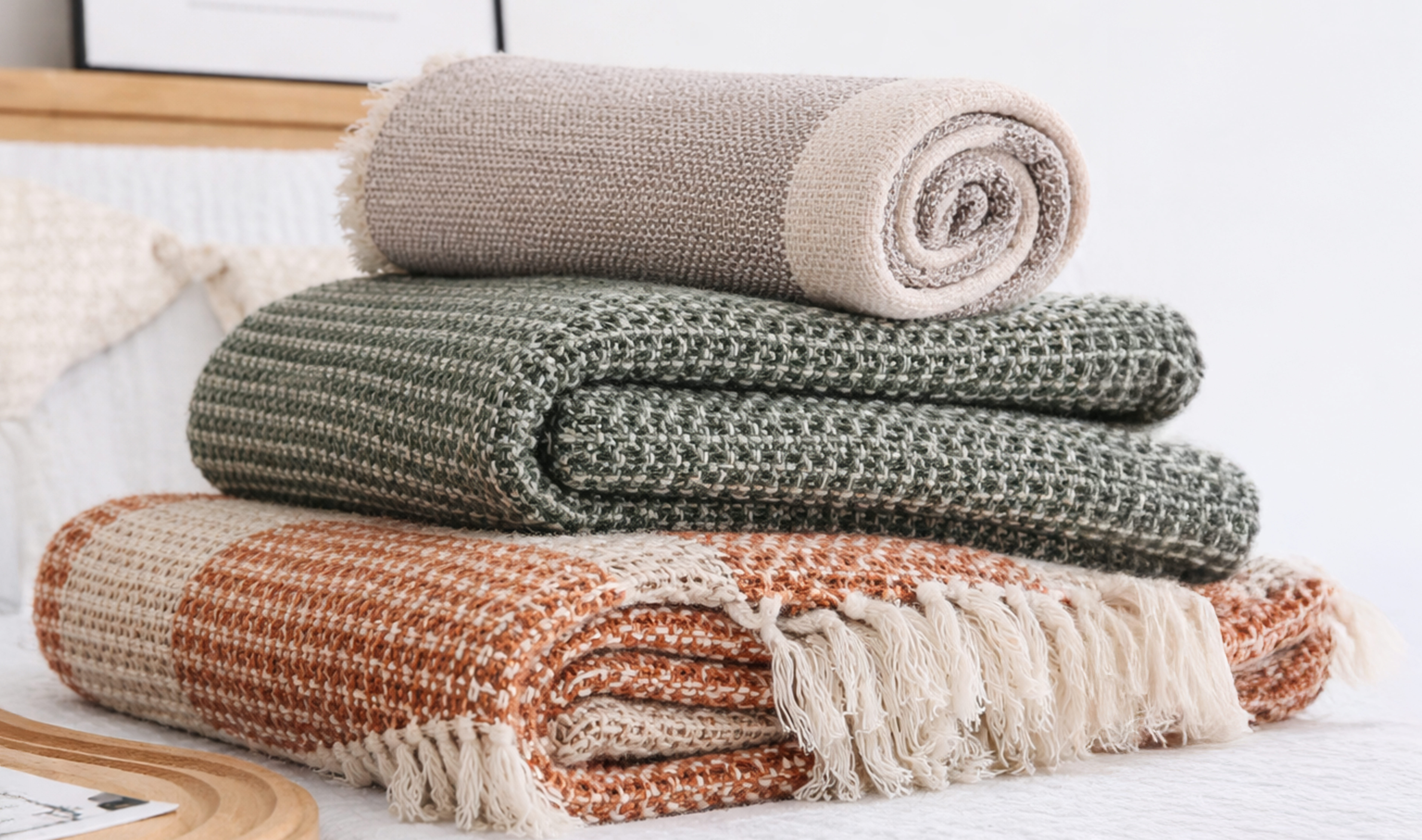 Folded decorative throws in natural tones.